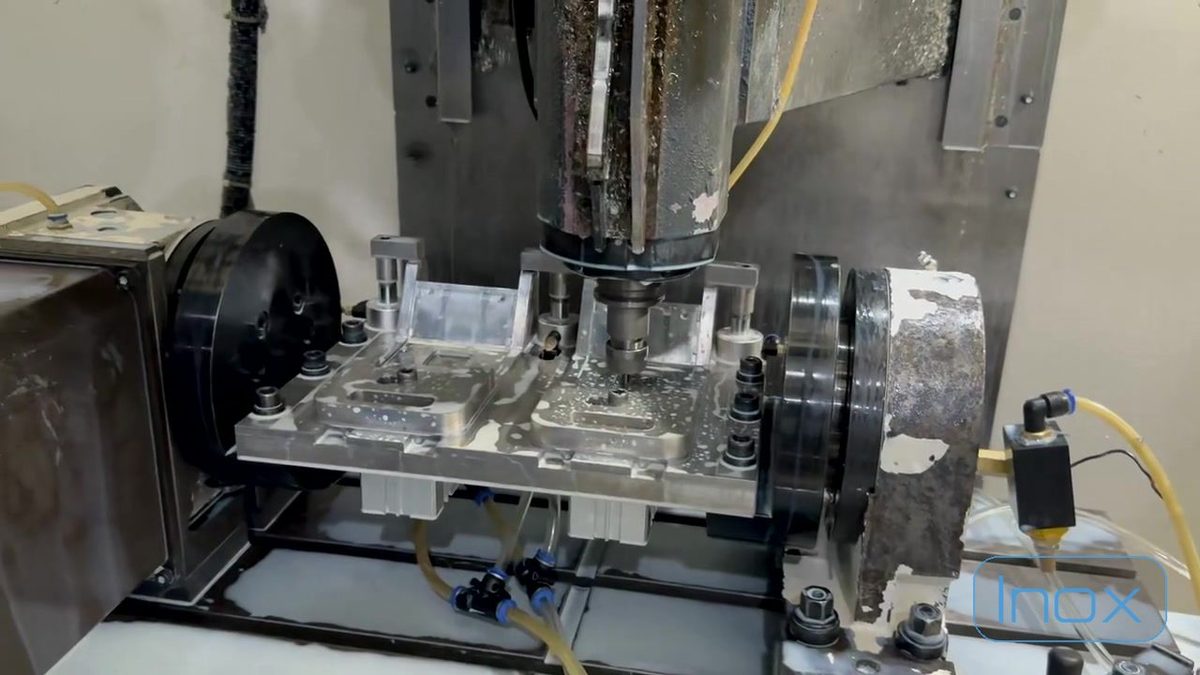 A die-cast part being machined under coolant inside a CNC cell
