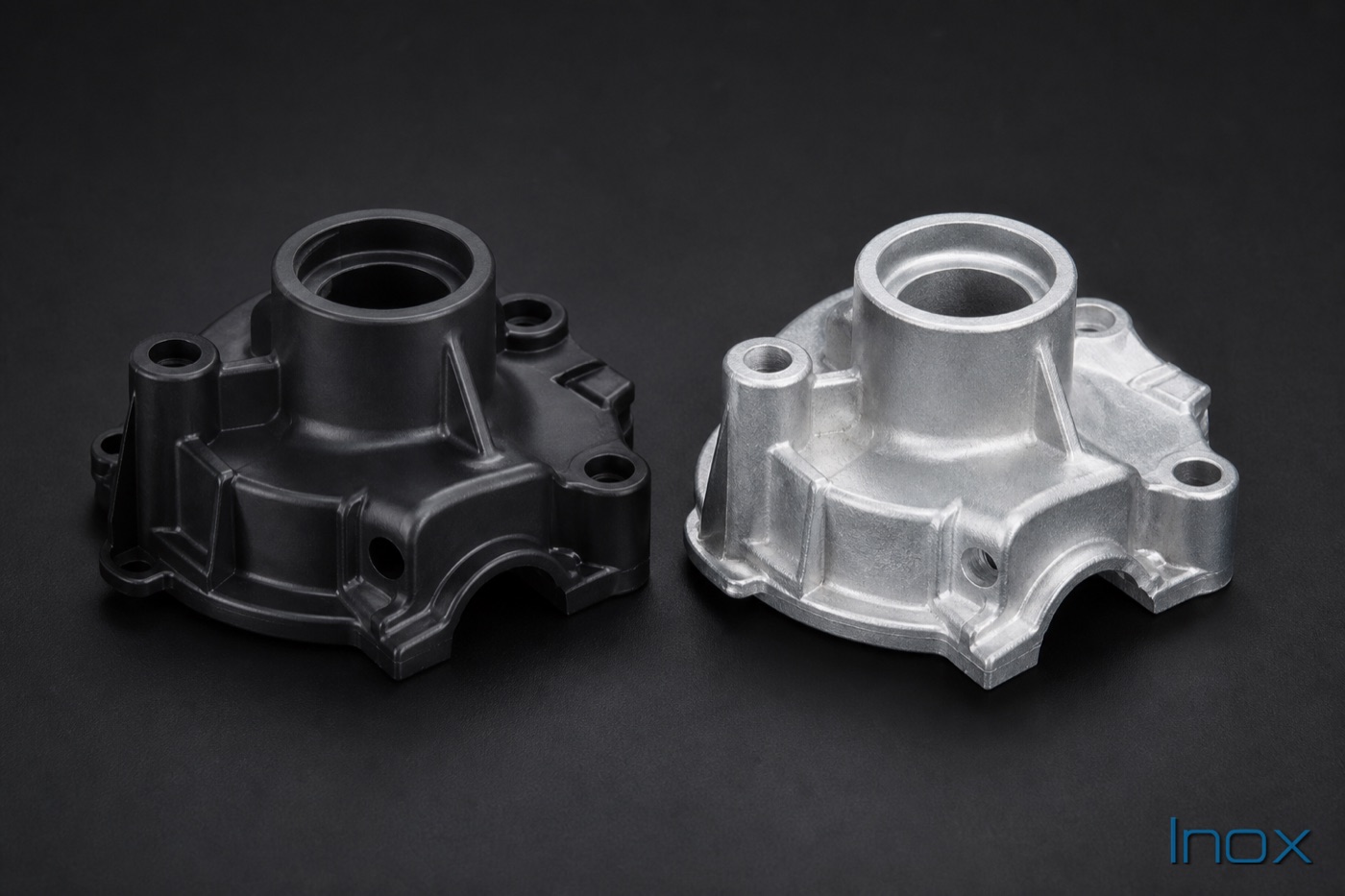 A plastic part beside its aluminum die-cast replacement